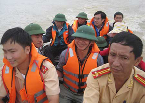 Trung tá Nguyễn Xuân Toàn và Trung úy Phạm Đức Thái lúc đang lái ca nô đưa hàng trăm người dân thoát khỏi vùng lũ.