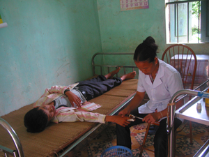 Cán bộ Trạm y tế xã Mường Chiềng (Đà Bắc) băng bó, điều trị cho nạn nhân bị thương tích do bất cẩn trong sử dụng công cụ sản xuất nông nghiệp.