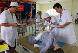 Ban giám khảo chấm điểm phần thi thực hành chăm sóc bệnh nhân trên mô hình.