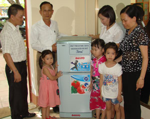 Ông Hoàng Công Đoài (người đứng giữa) và lãnh đạo  Phòng GD&ĐT huyện trong buổi tặng tủ lạnh cho cô, trò  trường mầm non Sơn Ca, thị trấn Hàng Trạm (Yên Thủy).
