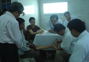 Các bác sĩ Bệnh viện Việt Đức khám sàng lọc cho bệnh nhân khuyết tật vận động.