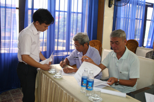 Cán bộ Phòng LĐ-TB&XH thành phố Hoà Bình hướng dẫn thân nhân người lao động Hàn Quốc ký cam kết vận động con em về nước đúng thời hạn.