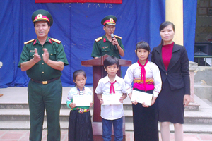 Lãnh đạo Đảng ủy-BGH trường Quân sự tỉnh trao tiền hỗ trợ cho các cháu học sinh nghèo hiếu học của xã Suối Nánh.