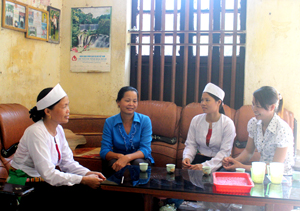 Chủ tịch Hội phụ nữ xã Định Cư, Lạc Sơn (thứ 2 từ trái sang) trò chuyện, vận động chị em xóm Bán Ngoài phấn đấu rèn luyện để được kết nạp Đảng.

