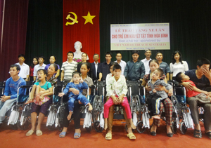 Đại diện Quỹ Bảo trợ trẻ em, tổ chức Vietnam Outreach (Australia), Sở LĐ, TB & XH trao xe lăn cho trẻ em tại huyện Tân Lạc.