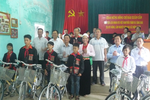 Đồng chí Đào Xuân Cần, Chủ tịch Liên minh HTX Việt Nam (người đứng thứ 3 từ trái sang) tặng xe đạp cho các em học sinh nghèo vượt khó tại HTX nông lâm nghiệp bản Dao xã Thống Nhất (TPHB).