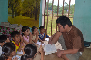 Anh Bùi Văn Bình ôn tập bài cho các em học sinh lớp 4.