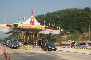 Nhiều phương tiện ô tô xếp hàng dài chờ đến lượt qua trạm thu phí trên tuyến QL6 – địa bàn huyện Lương Sơn.
