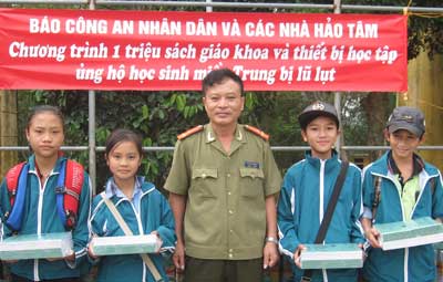 Thượng tá Nguyễn Hồng Thái - Trưởng ban Thư ký Toà soạn Báo CAND trao tặng máy tính, vở viết và sách giáo khoa cho học sinh Trường THCS Phong Hóa, huyện Tuyên Hóa.
