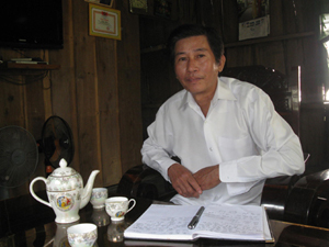 Thầy Trần Hòa trong ngôi nhà vách ván đơn sơ.