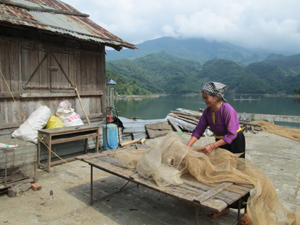 Người dân xã Tiền Phong (Đà Bắc) đang chuẩn bị lưới để thu hoạch cá lồng trên diện tích nuôi của gia đình.