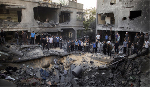 Người dân Palestine đứng quanh một hố bom sau cuộc không kích của Israel - Ảnh: CNN