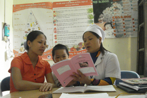Cán bộ Trung tâm YTDP huyện Tân Lạc tuyên truyền cách phòng bệnh cho phụ nữ có thai.