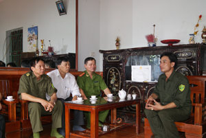 Anh Bùi Văn Cừ  (phải) trao đổi tình hình ANTT với Công an huyện Lương Sơn trong ngôi nhà của mình. 
