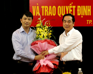 Đồng chí Nguyễn Văn Quang, Chủ tịch UBND tỉnh trao quyết định luân chuyển cán bộ và tặng hoa chúc mừng đồng chí Phạm Quốc Thắng.

