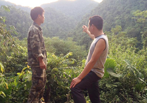 Anh Quách Văn Thần, trưởng ban tự quản xóm Rộc (bên trái) trao đổi với thành viên ban tự quản về công tác bảo vệ rừng.