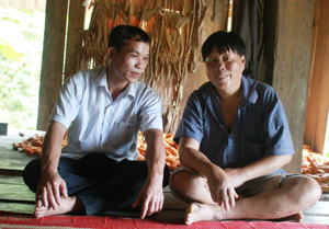 Ông Bùi Văn Lương (bến trái), trạm trưởng trạm y tế xã Tự Do đang thăm hỏi thường sức khỏe anh Bùi Văn Nhinh.