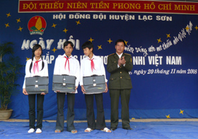 Cán bộ kiểm lâm Khu bảo tồn thiên nhiên Ngọc Sơn - Ngổ Luông tặng quà cho học sinh các xã vùng đệm huyện Lạc Sơn.