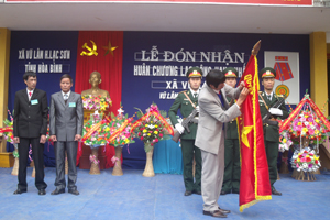 Thừa ủy quyền của Chủ tịch nước, đồng chí Bùi Văn Hiền, Phó Bí thư TT Huyện ủy Lạc Sơn gắn Huân chương Lao động hạng nhất lên lá cờ truyền thống của Đảng bộ, chính quyền nhân dân xã Vũ Lâm.