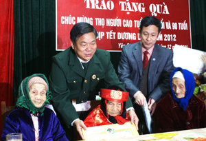 Đồng chí Bí thư Tỉnh ủy trao quà của Chủ tịch nước và của tỉnh cho cụ Nguyễn Thị Khỉu, 100 tuổi ở xóm Dủ, xã Yên Quang (Kỳ Sơn).