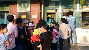 Người dân xếp hàng chờ rút tiền từ máy ATM ở Khu công nghiệp Long Thành, Đồng Nai - Ảnh: T.T.D.