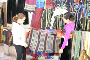 Chị Vì Thị Mai (phải) Bản Lác giới thiệu sản phẩm dệt thổ cẩm.