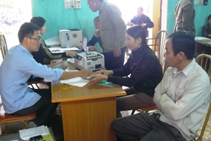 Cán bộ NHCSXH huyện Kỳ Sơn giải ngân vốn chương trình cho vay hộ SX-KD vùng khó khăn cho người dân tại điểm giao dịch xã Mông Hóa.

