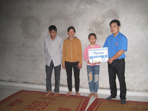 Đại diện Hội đồng Đội huyện Tân Lạc bàn giao nhà Khăn quàng đỏ cho gia đình em Bùi Thị Anh.