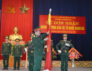 Thừa ủy quyền của Chủ tịch nước, Đại tá Bùi Văn Hùng, Chính ủy Bộ CHQS tỉnh gắn Huân chương Bảo vệ Tổ quốc hạng ba lên lá cờ truyền thống của Phòng Chính trị - Bộ CHQS tỉnh.