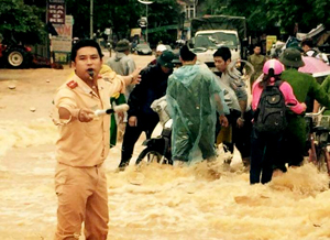 Cán bộ chiến sỹ Công an huyện Cao Phong không quản ngại nguy hiểm giúp dân vượt qua dòng lũ dữ vào cuối tháng 9 năm 2015.