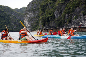 Du khách quốc tế khám phá Vịnh Hạ Long bằng thuyền kayak.