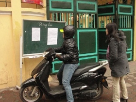 Phụ huynh đọc thông báo nghỉ học ở cổng Trường tiểu học Quang Trung, quận Hoàn Kiếm, Hà Nội.