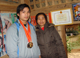 Nhà vô địch quốc gia Đinh Thế Bình bên mẹ cùng tấm huy chương vàng toàn quốc.