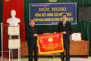 Đồng chí Bùi Tiến Lực, Chủ tịch LĐLĐ tỉnh trao cờ đơn vị dẫn đầu cho Công đoàn viên chức tỉnh.