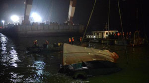 Các nhân viên cứu hộ đang tìm cách nâng con tàu bị chìm khỏi mặt nước. (Ảnh: Xinhua) 
