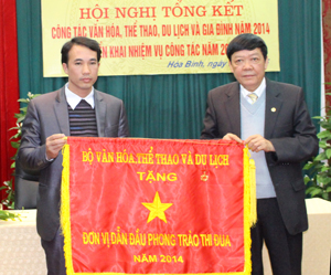 Thừa uỷ quyền, đồng chí Bùi Ngọc Lâm, Giám đốc Sở VH - TT & DL trao cờ thi đua của Bộ VH- TT & DL cho phòng VHTT huyện Kỳ Sơn.