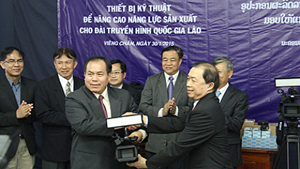Phó Tổng Giám đốc Đài THVN Trần Dũng Trình (bên phải) trao tặng thiết bị cho Tổng Giám đốc Đài THQG Lào Bun-chao Phi-chít.