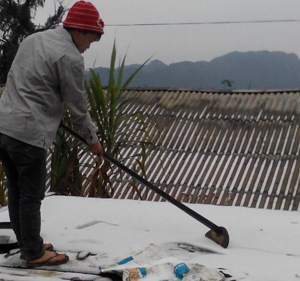 Nhân dân xóm Lài, xã Đồng Nghê dọn băng tuyết trên mái nhà.

