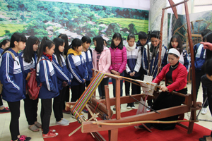 Các em học sinh trường THPT Công nghiệp tham quan, tìm hiểu nghề dệt vải truyền thống của người Mường.

