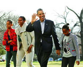 Ông Obama cùng vợ và hai con gái đi dạo phố.
