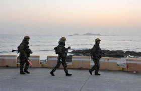 Các binh sĩ Hàn Quốc đi tuần trên đảo Yeonpyeong, nơi trúng pháo của Triều Tiên trong vụ đấu pháo hôm 23/11/2010.
