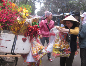 Các bà nội trợ tất bật mua sắm đồ lễ cúng Táo quân (một điểm bán đồ cúng lễ lưu động trong chợ Nghĩa Phương – thành phố Hòa Bình).