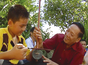 Ông Đinh Văn Tỉnh, xóm Đon, xã Mỹ Hòa (Tân Lạc) truyền đạt cách sử dụng nhạc cụ dân tộc cho thế hệ trẻ.