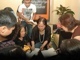 Nhà văn, đạo diễn Nguyễn Thị Minh Ngọc ký tặng người hâm mộ tại buổi giao lưu chiều 6-3
