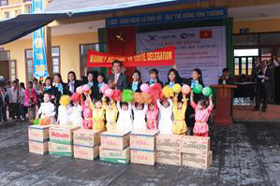 Đại diện công ty trao quà cho học sinh trường tiểu học Tam Dị.