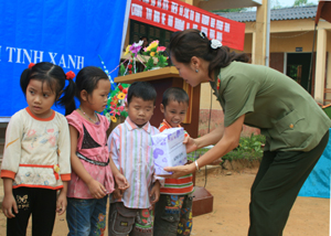 Đại diện Ban công tác nữ Công an tỉnh tặng quà cho các em học sinh nghèo vượt khó tại  xã Kim Tiến (Kim Bôi).