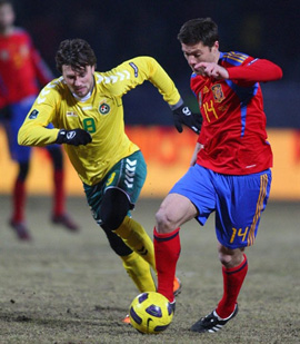Tiền vệ Xabi Alonso (áo đỏ) tranh bóng với một cầu thủ chủ nhà.