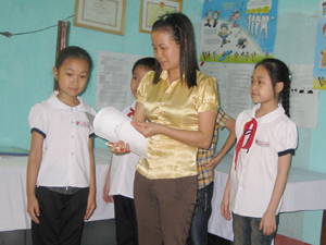 Cán bộ kế toán kiêm y tế học đường trường tiểu học Lê Văn Tám cân, đo theo dõi sức khỏe cho học sinh.