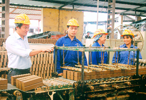 Kỹ sư Phạm Ngọc Thắng (thứ nhất từ trái sang)  kiểm tra chất lượng sản phẩm tại phân xưởng chế biến tạo hình gạch mộc.