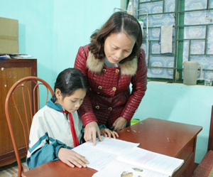 Cô giáo Nguyễn Thị Hồng, Phó hiệu trưởng trường THCS Ngọc Sơn hướng dẫn em Tùng học tập.